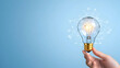 © Ajmeer - Hand-holding lightbulb icon with various symbols on blue background, representing ideas and innovation