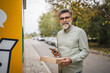 © Miljan Živković - Portrait of mature senior man stand near parcel machine with package