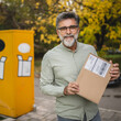 © Miljan Živković - Portrait of senior man stand in front parcel machine with package