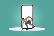 © Prostock-studio - A fit person is in an athletic pose, seemingly emerging from a large smartphone on a bright and cheerful backdrop, conveying a sense of energy and dynamism.