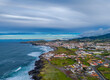 © Audrius - Ribeira Grande on the Atlantic ocean coast in Sao Miguel island, Azores, Portugal. Aerial drone view of city, cliffs and wavy ocean