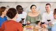 © JackF - Multiethnic women and men friends talking and drinking wine in the kitchen