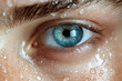 © huntspy - Close up of human eye with water droplets on skin, showcasing vibrant blue iris and detailed eyelashes, evoking sense of freshness and clarity