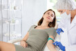 © JackF - Young happy woman is receiving injecting hypodermic against covid or flu.