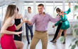 © JackF - Positive woman and man dancing foxtrot in pair during group dance party
