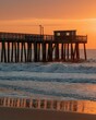 © jonbilous - A view of waves crashing beneath Avalon Fishing Pier during sunrise in Avalon, New Jersey.