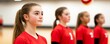 © lnwAI - A focused young female volleyball player stands at attention alongside teammates. The intensity reflects the dedication of youth sports training.