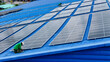 © ultramansk - top aerial of engineer men inspects construction of solar cell panel or photovoltaic cell at roof top. Industrial Renewable energy of green power. factory at urban area. worker working on tower roof.