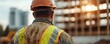 © Tonton54 - Construction workers back close - up concept. Construction worker observing a building site during sunset.