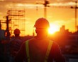 © Tonton54 - Construction workers back close - up concept. Construction workers watching sunset at a building site.