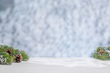 Aufkleber - Christmas template featuring snowy fir tree branches on a table with shadows and sun glares softly falling on the wall