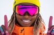 © tengah - A joyful skier wearing colorful gear and goggles, signaling excitement in a snowy landscape.