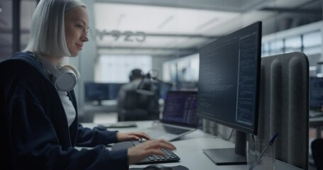 Female Software Developer Working on Computer in a Technological Laboratory, Writing Software Code. IT Programming Department Researching and Developing Commercial Internet Products. Zoom Out Footage