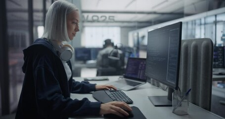 Young Caucasian Software Developer Working on Computer, Developing Code for Artificial Intelligence Project. Portrait Focused on a Creative Female Specialist with Headphones