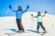 © Evaldas - Skiing family enjoying winter vacation on snow in sunny cold day in mountains and fun. Two skiers male and female pose with skis outdoors together having fun smile on holiday vacation