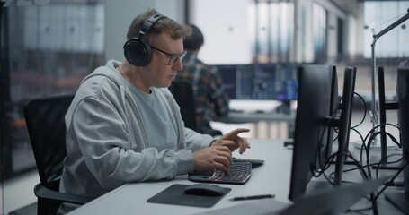 portrait of a male software developer working on computer in a technological office, writing softwar