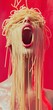 © GoodandEvil - Surreal spaghetti-clad person on red scenic backdrop.