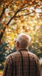 © kevin - a Retired Elderly Individual in a Nursing Home, Reflecting on Loneliness and Memories of Home. The Scene Features an Elderly Person Gazing Out at a Tree, Surrounded by Autumn Leaves Symbolizing Compa