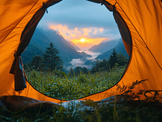 a colorful sunset with a camping tent set up in a grassy field with trees in the background.