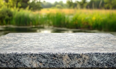 Aufkleber - A granite surface in a natural setting with blurred greenery and water in the background.