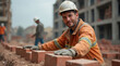 © bluebeat76 - Construction worker laying bricks at building site with blurred background banner concept