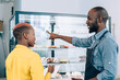 © BullRun - Black cafe staff at display with cakes in restaurant