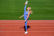 © Yevhen - Athletic fitness woman leg split is exercising outdoors. Young fit slim woman is doing stretch legs. Girl doing the stretch splits in the stadium. Leg-split, stretching in the stadium