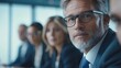 © Julia - Male mature caucasian ceo businessman leader with diverse coworkers team, executive managers group at meeting. Multicultural professional businesspeople working together on research plan in boardroom.