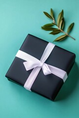 Wall Mural - A beautifully wrapped black gift box with a white ribbon on a vibrant turquoise background, symbolizing celebration and special moments.