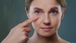 © Marko - Closeup of young woman pointing to the wrinkles on the upper eyelid