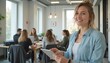 © Annetka - Happy businesswoman holding tablet during team meeting
