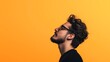 © Natalia - Profile of a man with curly hair and beard wearing glasses looking upwards against a bright yellow background