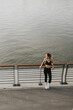 © BGStock72 - A confident athlete enjoys a moment of reflection while stretching on a riverfront path during golden hour