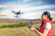 © Denis Rozhnovsky - A young woman controls a drone with a remote control in her hands.