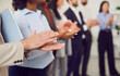 © Studio Romantic - Multicultural group of business people clapping, hands close-up. Successful team standing in a row applauding, shallow focus. Concept employee appreciation day, people meeting, business success