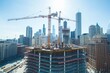 © Dmitry - Tower cranes on construction site in urban skyline. Skyscrapers in cityscape with ongoing high-rise construction project