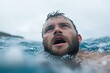 © Milos - In a scene of urgency, a man with an intense expression is swimming in rough sea waves, conveying emotions of determination and survival against nature’s elements.