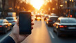 © Selene Studio - Smartphone in Hand Against Sunset City Traffic Blur, mobile phone, cell phone, holding, cars, blurred background