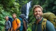 © Evgenii - A group of three hikers stands in a vibrant forest, smiling and carrying backpacks. The background features a cascading waterfall, highlighting the beauty of nature and adventure