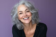 © Infinity Lens - Middle-aged woman with natural grey curls laughing genuinely, soft purple backdrop.
