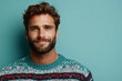 © Odin AI - Portrait of a young man with a short beard wearing a colorful Christmas sweater, standing confidently against a plain light blue background, portraying modern festivity.