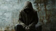 © Thiago - Hooded figure sitting on a grunge wall. Enigma. Illustration
