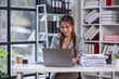 © David - Young asian attractive businesswoman working on her project with laptop computer in modern office room. business plan investment, finance analysis concept.