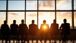© LifeMedia - A team of business professionals silhouetted against a stunning sunset in a high-rise office, collaborating and exchanging ideas in a modern corporate environment.