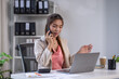 © David - Attractive and professional millennial business Asian woman freelancer making telephone call share good news about project working in office workplace, business finance concept.