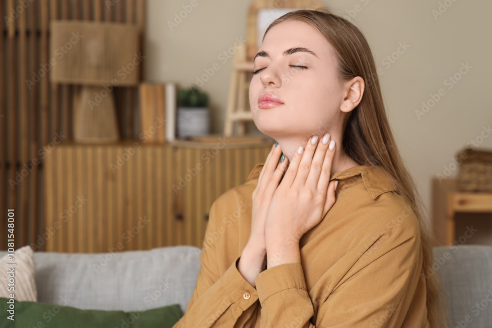 Young woman self-examining thyroid gland at home