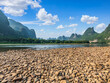 © ABCDstock - Beautiful mountain and water nature landscape in Guilin, China. Pebble beach and river with karst mountain scenery in summer.