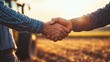 © Chotijah - Two Farmers Shaking Hands in a Field at Sunset