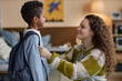 © Seventyfour - Side view of happy adoptive mother adjusting sons clothes while preparing little Black boy for school in kids room
