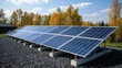 © Рудой Максим - Solar panels installed on a gravel base with a backdrop of autumn trees under a clear blue sky in a renewable energy project